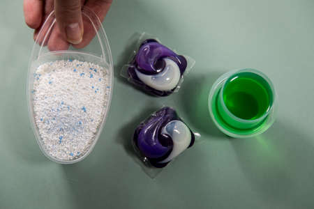 Woman choosing from laundry detergent variety of powder, liquid gel and pod for washing clothes