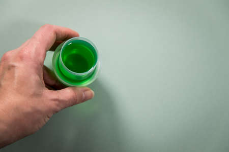 Woman with green liquid laundry detergent gel for washing clothes