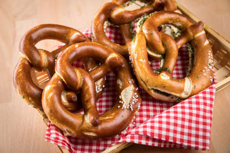 German soft Brezel pretzel with salt, chives and butter in bread basketの写真素材