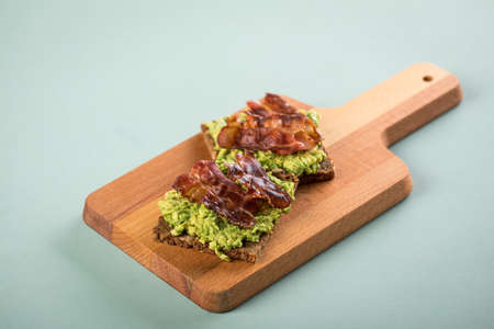 Avocado bacon on sunflower seed whole grain bread slice for breakfast or snackの写真素材