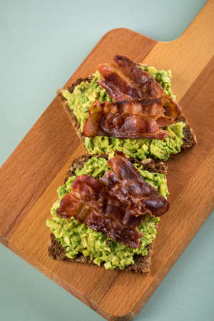 Avocado bacon on sunflower seed whole grain bread slice for breakfast or snackの写真素材