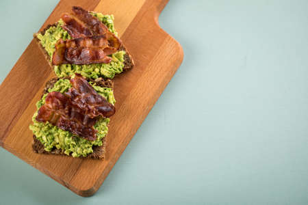 Avocado bacon on sunflower seed whole grain bread slice for breakfast or snack
