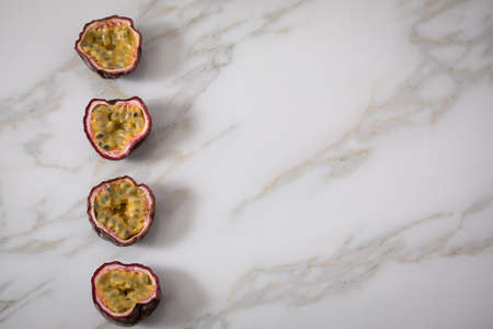 Ripe passion fruits line up in row on marble backgroundの写真素材