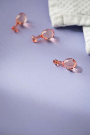 Face skin care beauty serum ampule and white terry cloth towel on lilac background