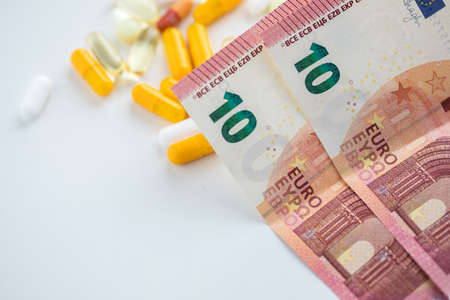 Money bills for white and yellow pills, tablets and capsule medicineの写真素材