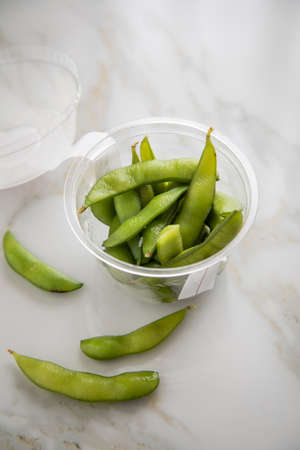 Portion Japanese Edamame soy beans in plastic take away tray bowl