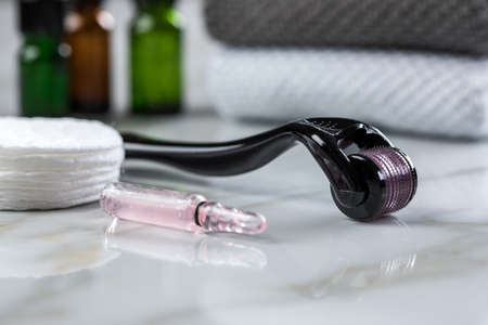 Derma roller and cosmetic vial ampoule for anti ageing lifting treatment in cosmetologist beauty...