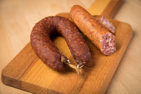 Air dried pork sausage ring and German BierbeiÃer are two sorts of Salami on wooden boardの写真素材