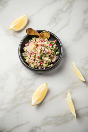 German Friesland north sea brown shrimps salad in bowl with cucumber, red radish, dill and lemon on...