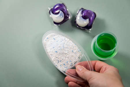 Woman choosing from laundry detergent variety of powder, liquid gel and pod for washing clothesの写真素材