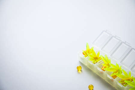 Pills, tablets,  capsules of cannabis marijuana hemp and CBD as pain killer and medical therapy in box dispenserの写真素材