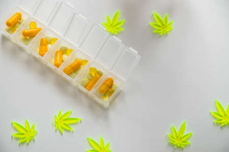 Pills, tablets,  capsules of cannabis marijuana hemp and CBD as pain killer and medical therapy in box dispenserの写真素材