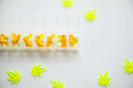 Pills, tablets,  capsules of cannabis marijuana hemp and CBD as pain killer and medical therapy in box dispenserの写真素材