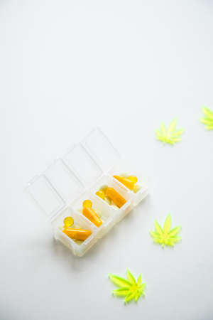 Pills, tablets,  capsules of cannabis marijuana hemp and CBD as pain killer and medical therapy in box dispenserの写真素材