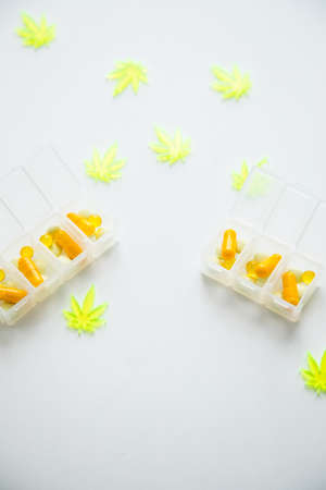 Pills, tablets,  capsules of cannabis marijuana hemp and CBD as pain killer and medical therapy in box dispenserの写真素材