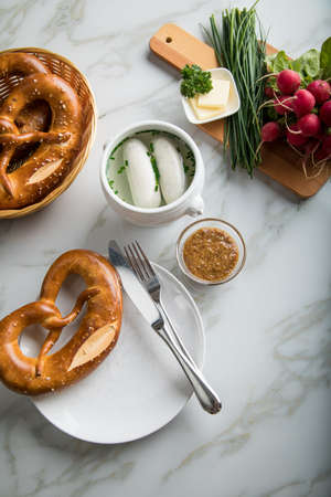 German WeiÃŸwurst white sausage in porcelain pot, Bavarian sweet mustard, butter, chives, radish...