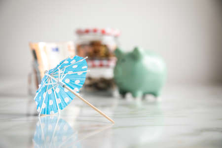 3 glass jars with Euro notes, sunshade, 2â¬ coins and loose cash for housekeeping and vacation savingsの写真素材
