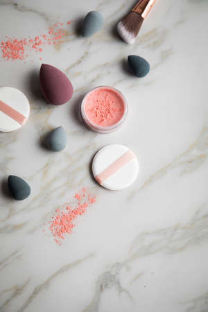 Loose rouge make-up powder with blender, sponge and brush on marble beauty tableの写真素材