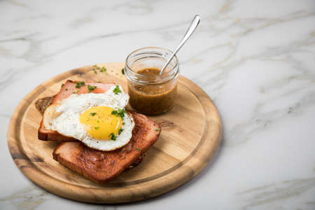 Roasted Bavarian LeberkÃ¤se meat loaf with fried egg on sunflower seed bread with sweet mustard on...