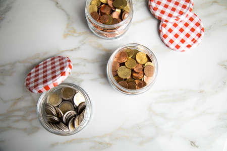 3 glass jars of loose cash and 2â‚¬ coins for housekeeping money, vacation or saving goals
