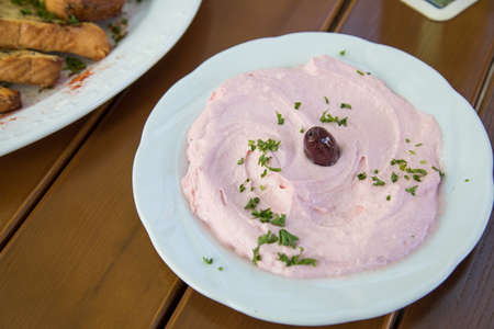 Greek Taramosalata Tarama salad as starter in restaurant on wooden table