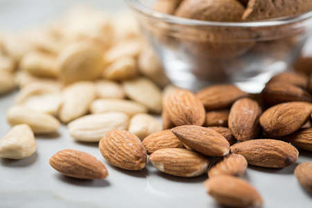 Almonds as whole nut, unpeeled kernel and blanched peeled on marble backgroundAlmonds as whole nut, unpeeled kernel and blanched peeled on marble backgroundの写真素材