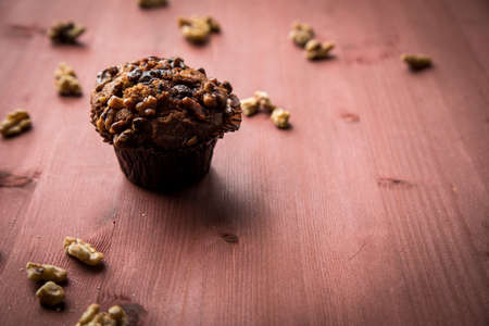 Walnut muffin and nuts and red brown wooden table backgroundの写真素材