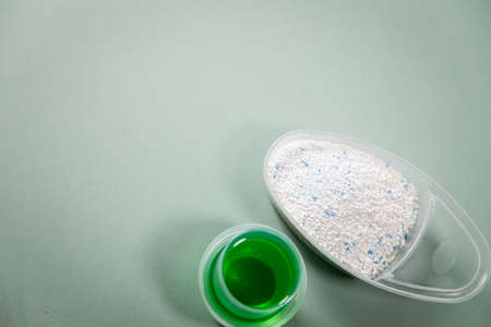 Woman choosing from laundry detergent between of powder and liquid gel for washing clothesの写真素材