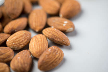 Unpeeled brown almond nuts on marble background