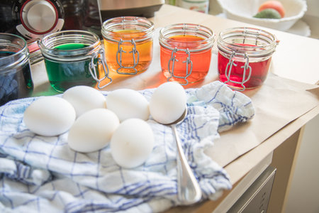 Boiled eggs with bright Easter cold color color dye in red, orange, yellow, green, blue in glass jar...