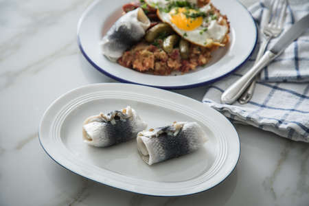 North German Hamburg Labskaus is a delicacy with corned beef, potatoes, beetroot, pickled gherkins, fried egg and herring on enamel plateの写真素材