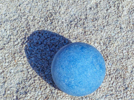 Bocce balls displayed on a gravel courtの写真素材