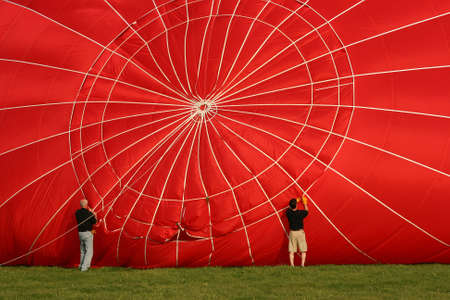 Two men preparing a hot air balloon for flightの写真素材
