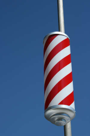 Barber shop red and white spiral sign on poleの写真素材