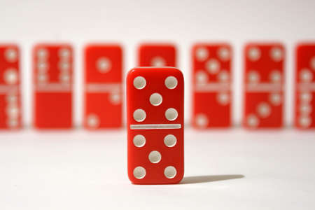 Red dominoes set against a white backgroundの写真素材