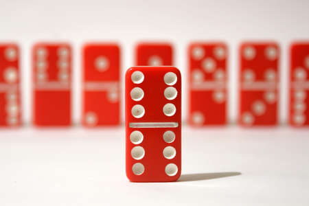 Red dominoes set against a white backgroundの写真素材