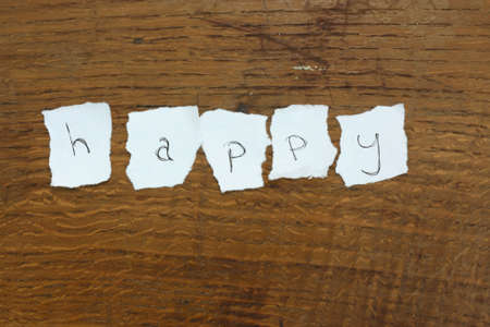 Message made of letters on torn paper on a wooden backgroundの写真素材
