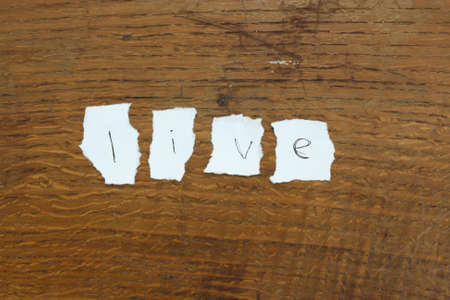 Message made of letters on torn paper on a wooden backgroundの写真素材