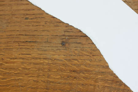 Torn piece of paper on a wooden backgroundの写真素材