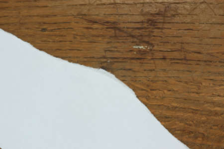 Torn piece of paper on a wooden backgroundの写真素材