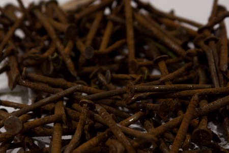 A pile of rusty nails spread out on a table