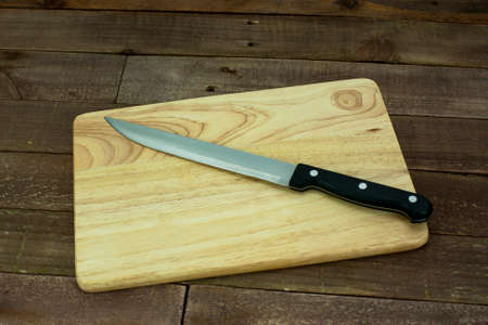 Wooden chopping board with an old knifeの写真素材