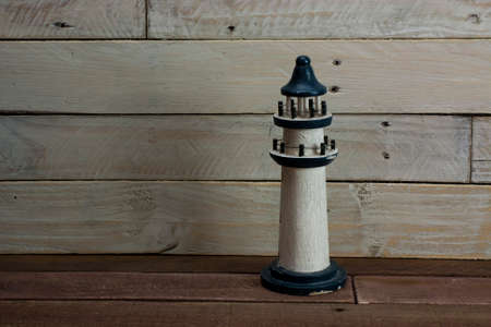 Lighthouse set against a worn wooden backgroundの写真素材