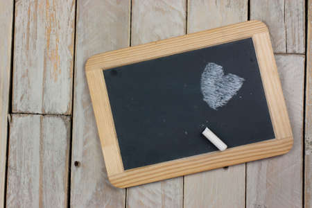 Small blackboard with chalk on a wooden backgroundの写真素材