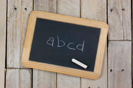Small blackboard with chalk on a wooden backgroundの写真素材