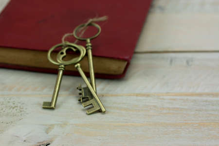 Close up of old vintage keys and book on a rustic background.の写真素材