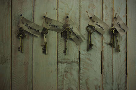 Set of old antique keys on a wooden background. Vintagefilter applied.の写真素材