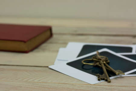 Close up of old vintage keys, book and photographs on a rustic background.の写真素材