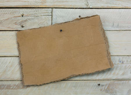 Distressed cardboard sign on a wooden backgroundの写真素材