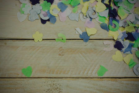 Close up of confetti on a wooden background. Vintage filter applied.の写真素材